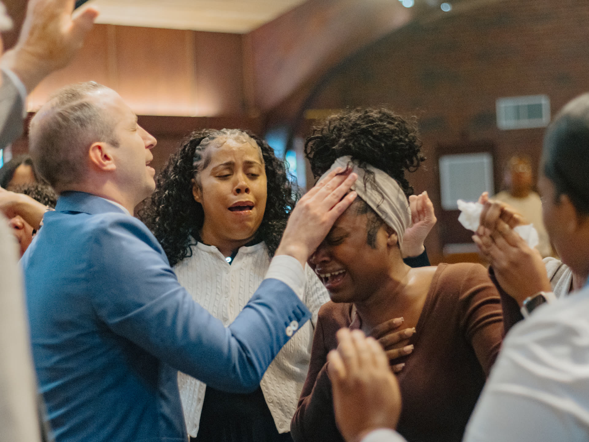 The church praying over a weeping woman at the altar